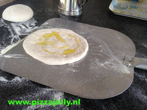 pizzabroodje met olijfolie op pizzaschep van PIZZAJOLLY pizzaovens