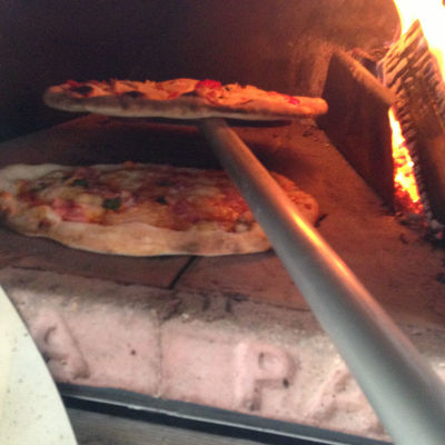 Pizza bakt, naast het hete houtvuur, in minder dan een minuut lekker krokant in de houtegstookte pizzaoven van PIZZAJOLLY!