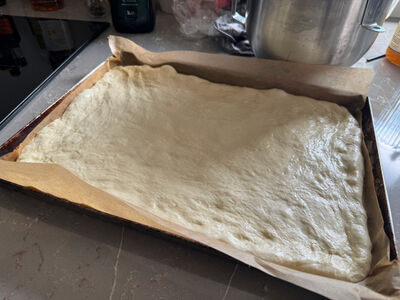 focaccia deeg op de bakplaat verdelen